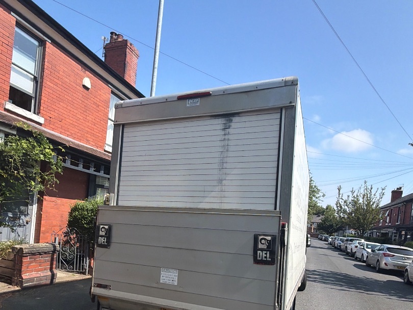 A Luton box van parked outside a red-brick terrace, ready to load