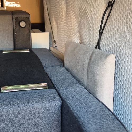 A corner sofa in sections and a mattress loaded in a van